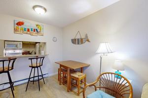 a living room with a table and chairs and a kitchen at The Condo at Ocean Edge in Brewster +17 photos