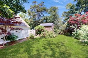a yard with a house and a fence and trees at Brewster Getaway in Brewster