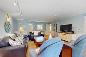a living room with couches and a flat screen tv at Brewster Getaway in Brewster