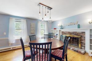 a dining room with a table and chairs and a fireplace at Brewster Getaway in Brewster