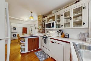 a kitchen with white cabinets and a sink at Beach House in Oak Bluffs +17 photos