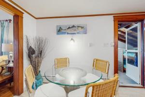 a dining room with a glass table and chairs at Mermaid Cottage in Falmouth