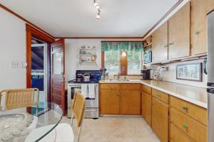 a kitchen with wooden cabinets and a stove top oven at Mermaid Cottage in Falmouth +7 photos