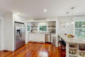 a kitchen with white cabinets and a stainless steel refrigerator at Edgartown Village in Edgartown