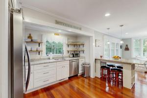 a large kitchen with white cabinets and a hard wood floor at Edgartown Village in Edgartown +18 photos
