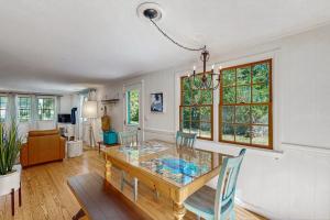 a dining room with a glass table and chairs at Miles Away in South Dennis +24 photos