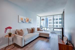 a living room with a couch and a large window at The Canadian in Vancouver