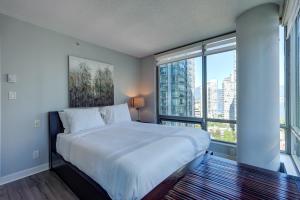 a bedroom with a large bed with a large window at The Canadian in Vancouver