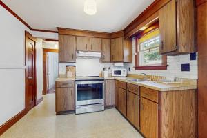 a kitchen with wooden cabinets and a stove top oven at The Cygnet in Falmouth