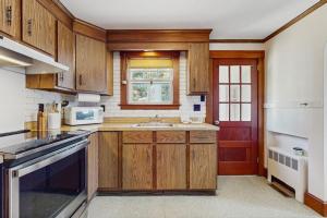 a kitchen with wooden cabinets and a sink at The Cygnet in Falmouth +9 photos