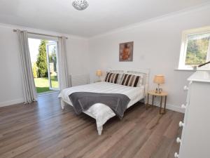 a white bedroom with a bed and a wooden floor at 2 Bed in Lamesley oc-cn107 in Lamesley