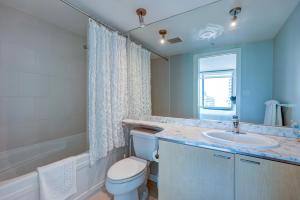 a bathroom with a toilet and a sink and a mirror at The Canadian in Vancouver +19 photos