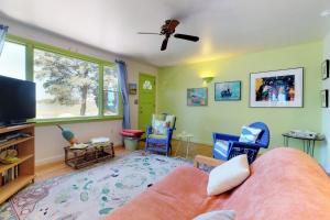 a living room with a couch and chairs and a flat screen tv at Sunset Meadows in Oak Bluffs