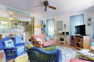 a living room with blue and pink chairs and a television at Sunset Meadows in Oak Bluffs