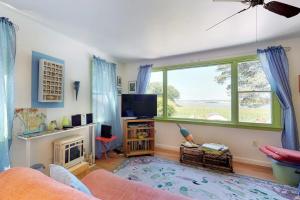 a living room with a large window and a television at Sunset Meadows in Oak Bluffs
