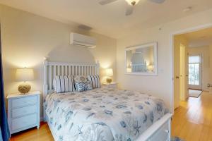 a bedroom with a bed with a blue and white comforter at Bayside Beauty in Truro