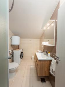a white bathroom with a toilet and a sink at Regina del Mare in Slatine +100 photos