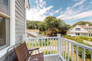 a balcony with a chair and a view of a house at Bella Luna in Falmouth