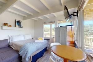 a bedroom with a bed and a table and a tv at Sand & Beach Within Reach in North Truro