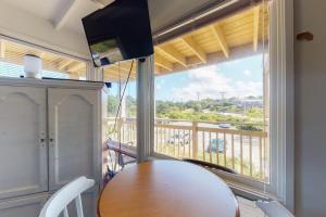 a dining room with a table and a large window at Sand & Beach Within Reach in North Truro
