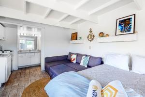 a living room with a purple couch and a kitchen at Sand & Beach Within Reach in North Truro