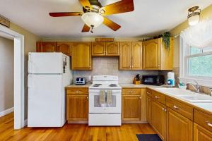 a kitchen with a white refrigerator and a ceiling fan at Winthrop Cottage in Oak Bluffs