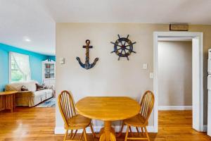 a dining room with a wooden table and chairs at Winthrop Cottage in Oak Bluffs +12 photos