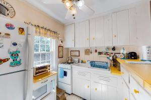 a kitchen with white cabinets and a white refrigerator at The Spray in Harwich Port