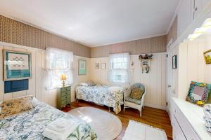 a bedroom with two beds and a chair at The Spray in Harwich Port +7 photos