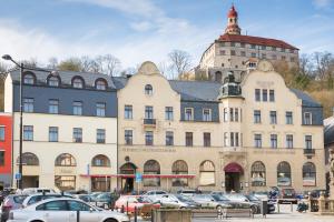 un gran edificio con coches estacionados en un estacionamiento en Hotel U Beránka Náchod, en Náchod