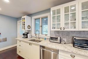 a kitchen with white cabinets and a sink at Bayview in Truro