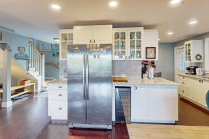 a kitchen with a stainless steel refrigerator and white cabinets at Bayview in Truro +33 photos