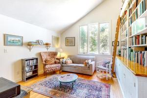 ein Wohnzimmer mit Sofa und Bücherregal in der Unterkunft Hillside Oak in Chilmark