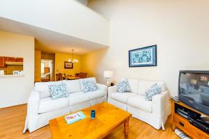 a living room with two white couches and a tv at Relaxing Cape Getaway in Brewster
