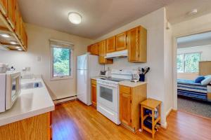 a kitchen with wooden cabinets and white appliances at Relaxing Cape Getaway in Brewster +17 photos