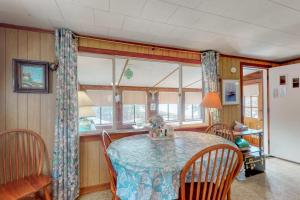 a dining room with a table and chairs and windows at Villa Fairview in South Dennis