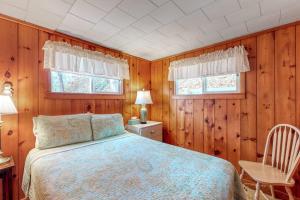 a bedroom with a bed and a table and two windows at Villa Fairview in South Dennis +19 photos
