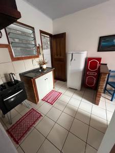 a kitchen with a stove and a refrigerator at Casa beira mar Jacaraipe. in Serra