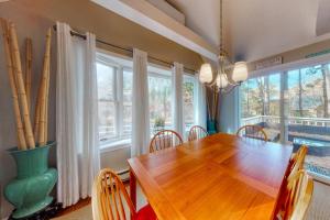 a dining room with a wooden table and some windows at Sit Back & Relax in Eastham