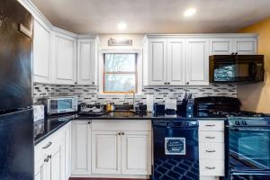 a white kitchen with a sink and a stove at Brewster House in Oak Bluffs