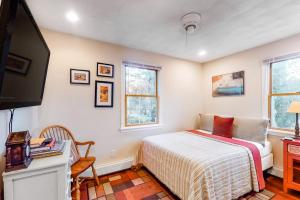 a bedroom with a bed and a flat screen tv at Brewster House in Oak Bluffs