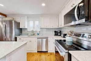 a kitchen with white cabinets and stainless steel appliances at Cape Cod Playhouse in Yarmouth +16 photos