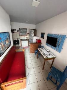a living room with a red couch and a table at Casa beira mar Jacaraipe. in Serra