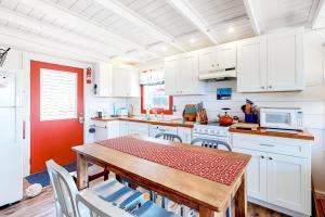 a kitchen with white cabinets and a table with chairs at Dunes Edge in Wellfleet