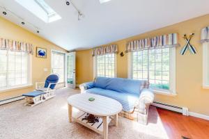 a living room with a blue couch and a table at Mattakeese Villa in Yarmouth