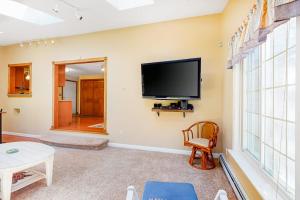 a living room with a flat screen tv on the wall at Mattakeese Villa in Yarmouth
