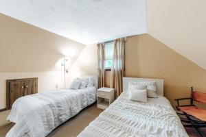 a bedroom with two beds and a window at Lake Shore Living in Falmouth