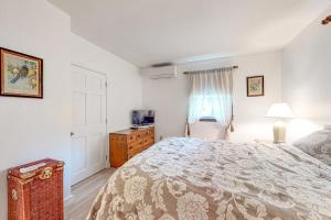 a white bedroom with a large bed and a window at Lake Shore Living in Falmouth