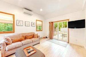a living room with a couch and a flat screen tv at Lake Shore Living in Falmouth +17 photos