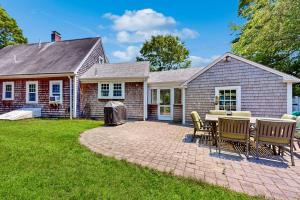 a house with a patio with chairs and a table at Ocean Bird Nest in South Yarmouth